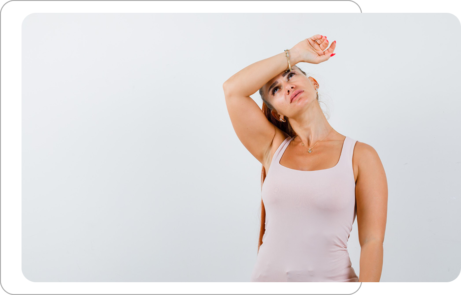 Kobieta w jasnym topie wykonująca rozciąganie szyi z uniesioną ręką przy czole na jasnym tle.