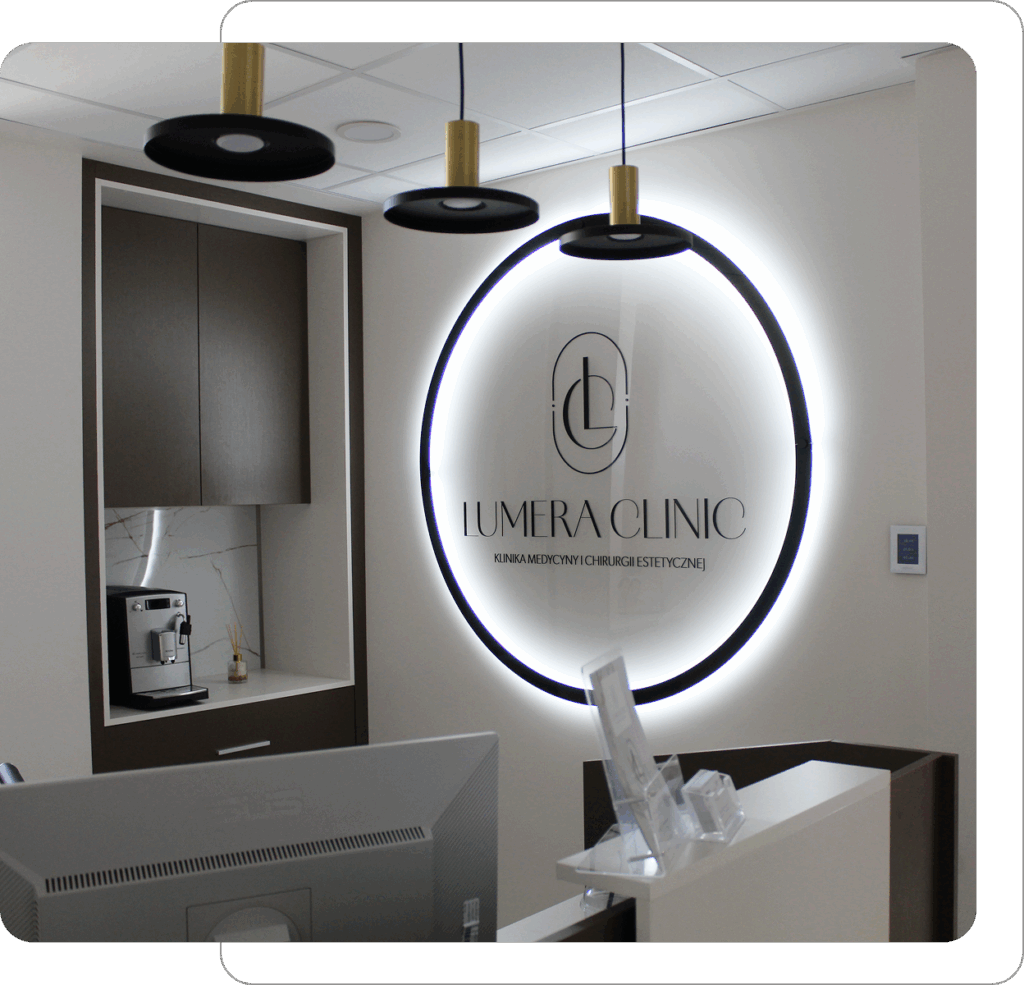 Recepcja Lumera Clinic z podświetlonym logo na ścianie.